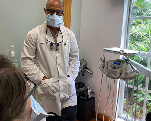 Dr. Larry Saylor consulting with patient sharing recommended dental plan to have healthy teeth and gums